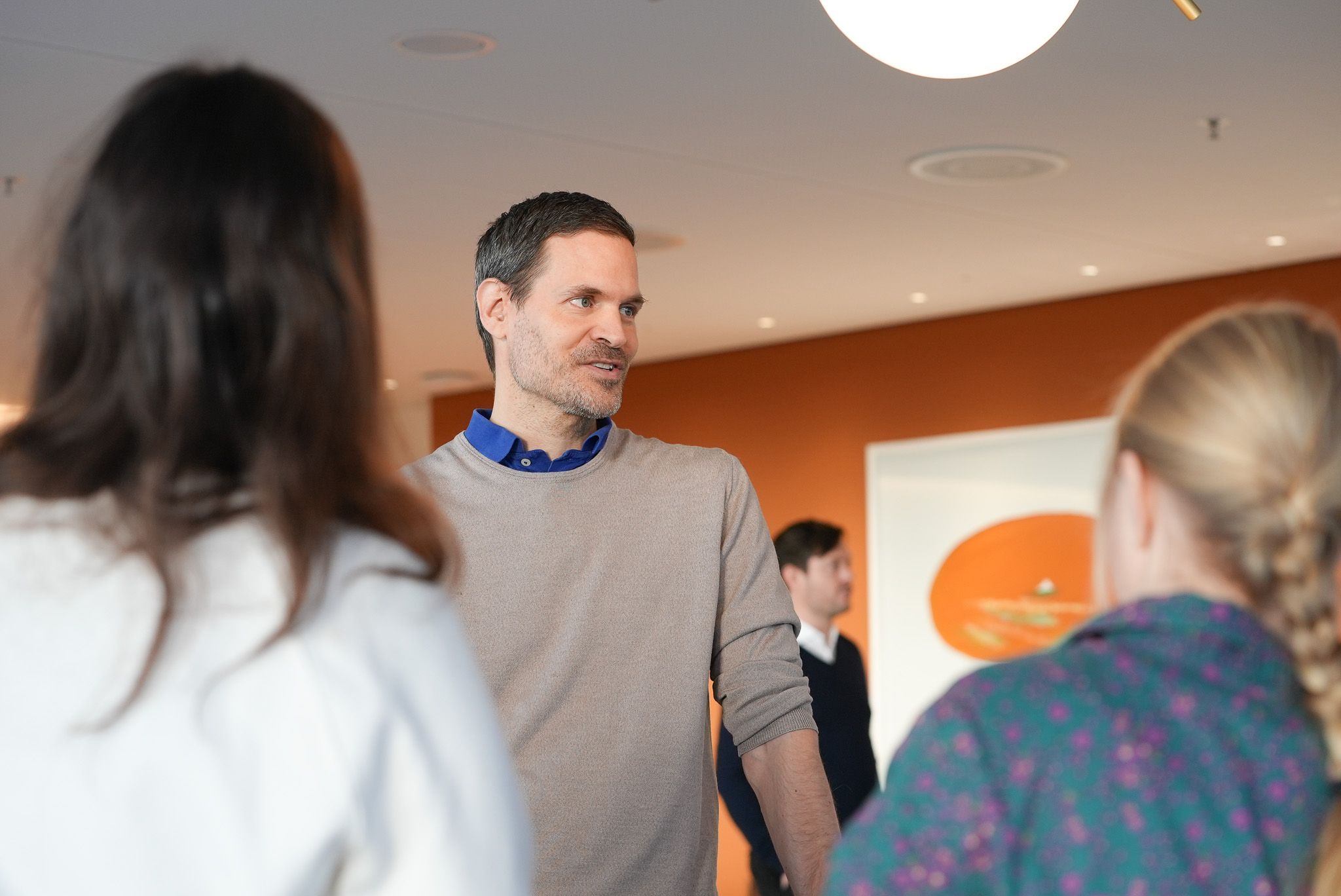 Benjamin Otto im Gespräch mit zwei Leuten.