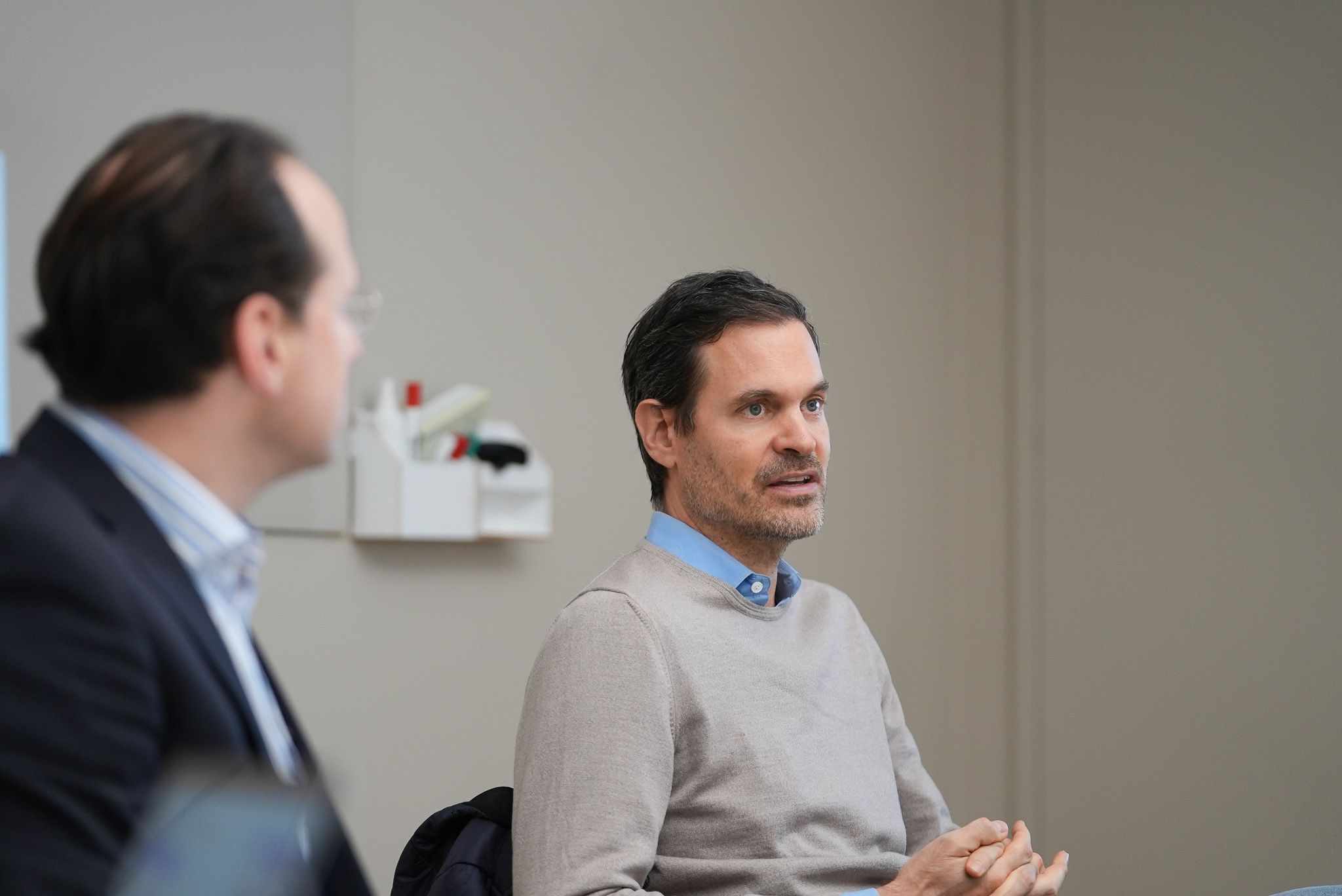 Benjamin Otto sitzt mit einer weiteren Person in einem Büro. 